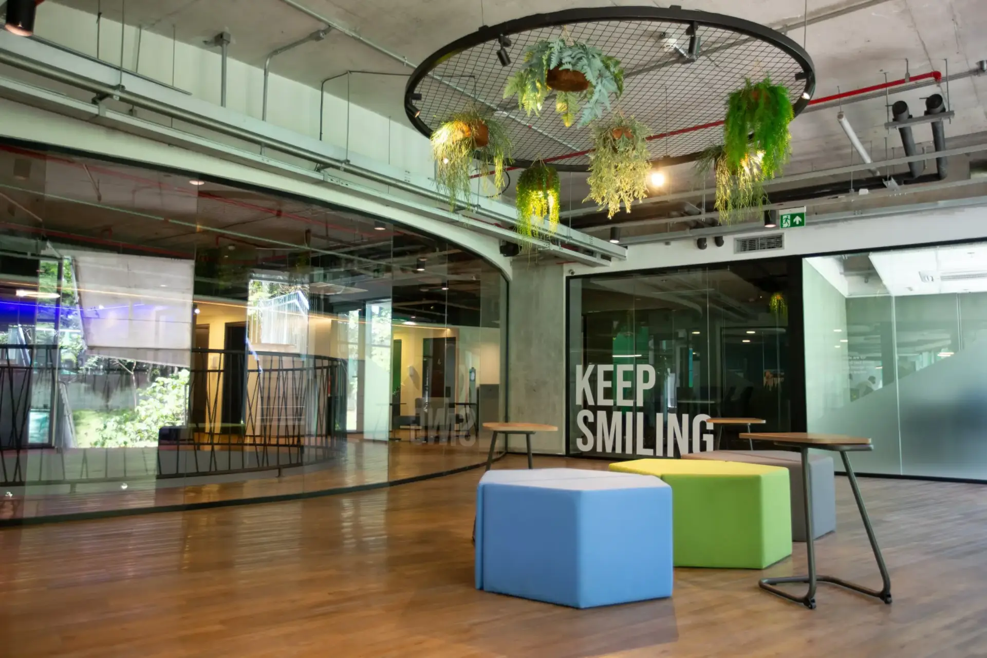Lounge do Base Coworking com frase “Keep Smiling” em um vidro.