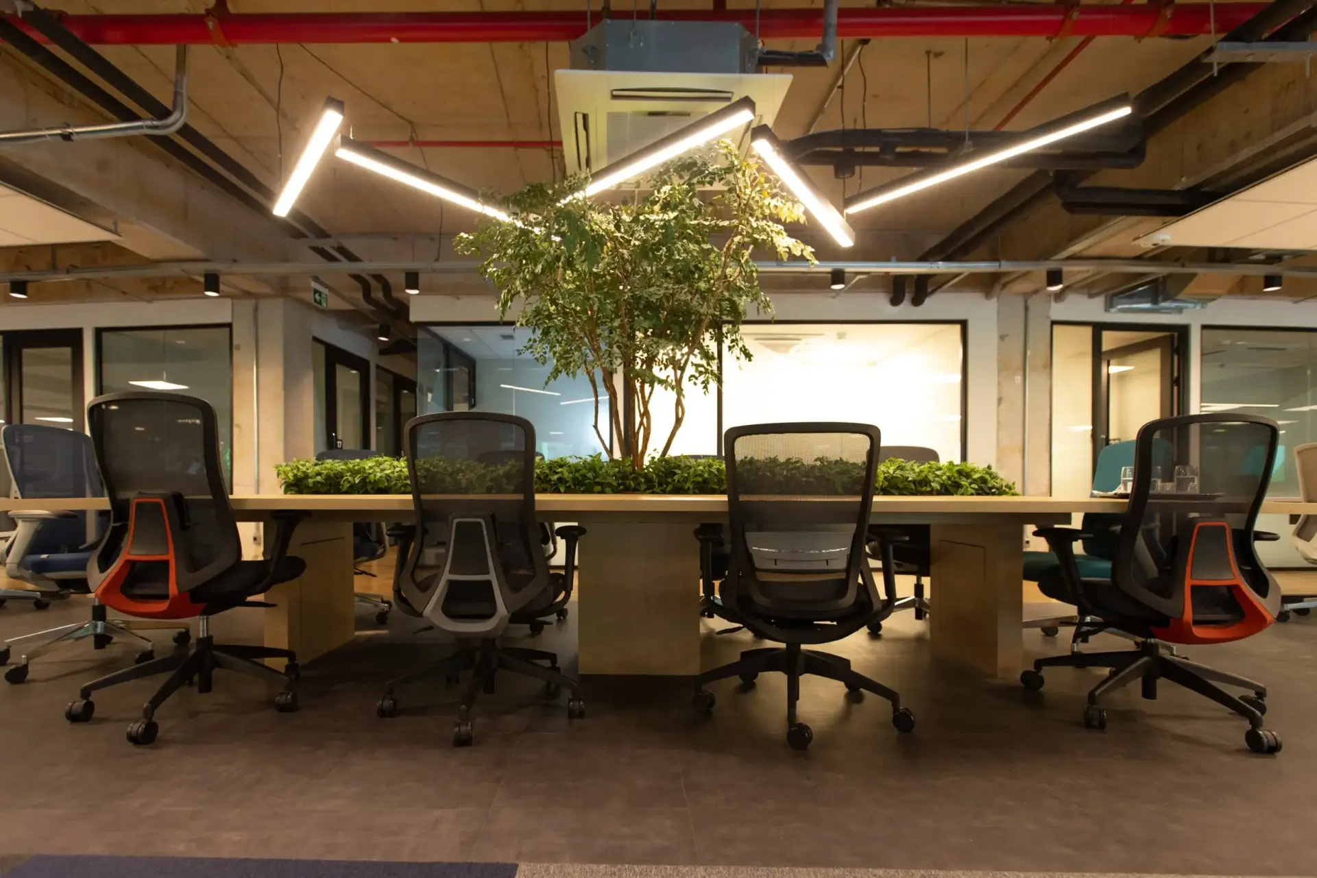 Foto de escritório compartilhado do Base Coworking com mesa e cadeiras de trabalho ao redor.
